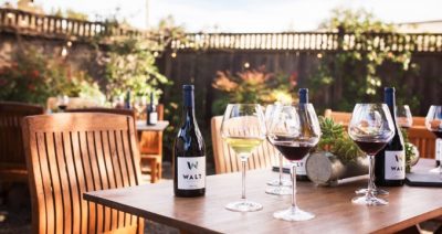 Walt Wines picture with glasses of wine sitting on an outdoor table.